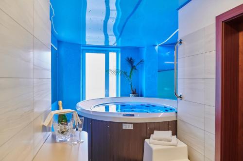 海布考莫尼壶卡酒店的一间带浴缸的浴室和蓝色的天花板