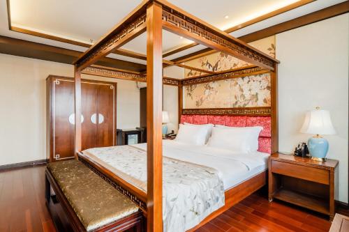 成都成都圆和圆佛禅客栈的一间卧室配有四柱床和一盏灯。