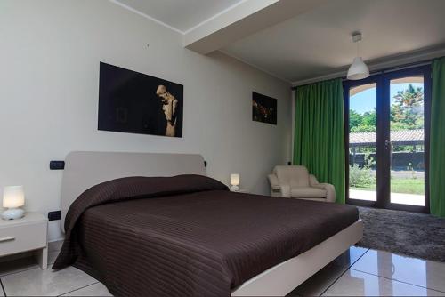阿奇雷亚莱Tenuta Santa Tecla的一间卧室配有一张大床和绿帘