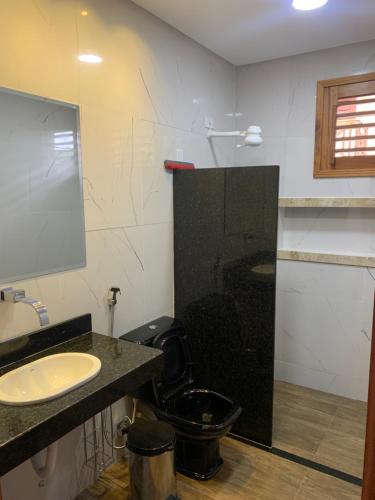 蒂安瓜Sítio do Bosco Park的浴室设有黑色的卫生间和水槽。