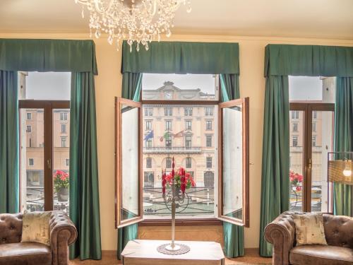 威尼斯Grand Canal Suite by Wonderful Italy的客房 - 带两把椅子和一扇带绿色窗帘的窗户