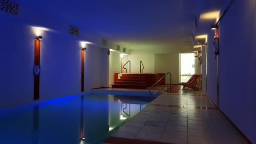 尼彻兹Akwamaryn Spa Niechorze的蓝色灯光的房间的游泳池