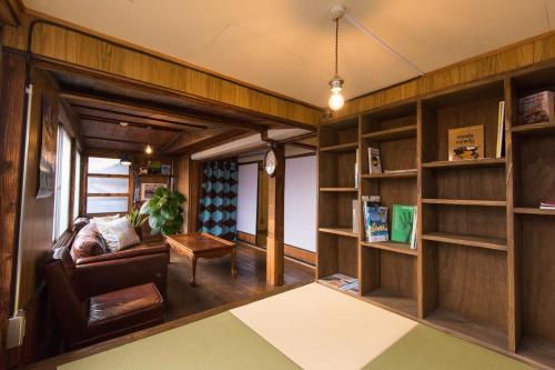 长野DOT HOUSE NAGANO Traditional Japanese house - Vacation STAY 82102的带沙发和书架的客厅