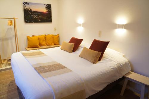 根特Well-situated and Comfortable Home的卧室配有带橙色枕头的大型白色床