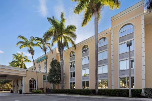 黎明城La Quinta Inn & Suites by Wyndham Sunrise的一座棕榈树的办公楼