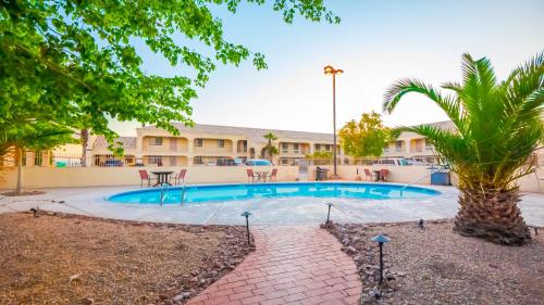 针城里约多索酒店的一座建筑前的游泳池,里面种着棕榈树