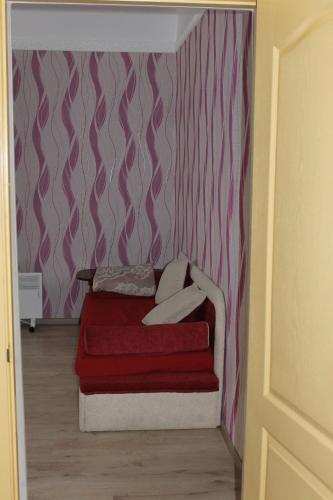 切尔尼戈夫Исторический центр的一张小床,位于一个红色毯子的房间