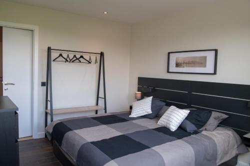 Wezembeek-OppemCocoon in East-Brussels的一间卧室配有一张大床,提供黑白毯子
