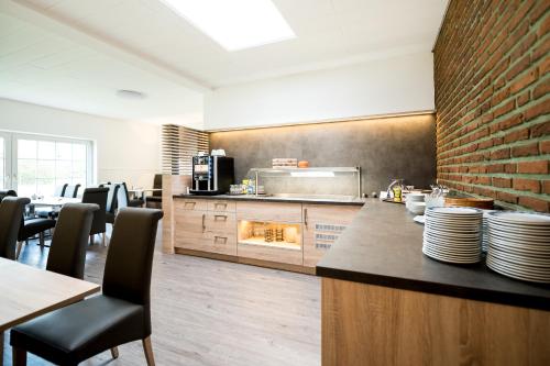明斯特Hotel Hüerländer的厨房配有桌椅和砖墙