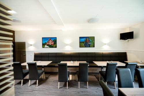 明斯特Hotel Hüerländer的一间带桌椅和电视的用餐室