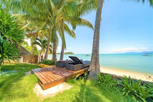 班拉克海滩爱侣湾别墅酒店的棕榈树海滩上的长凳