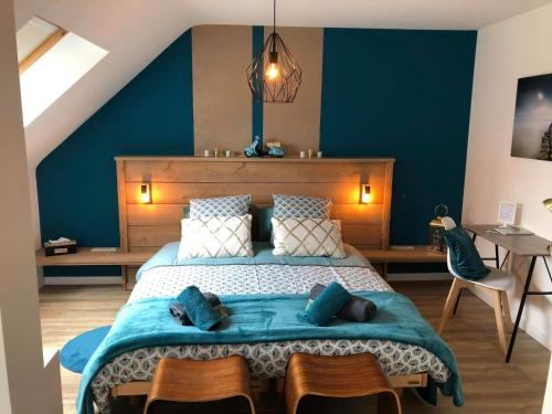 滑铁卢la chambre de lola的一间卧室配有一张带蓝色墙壁的大床