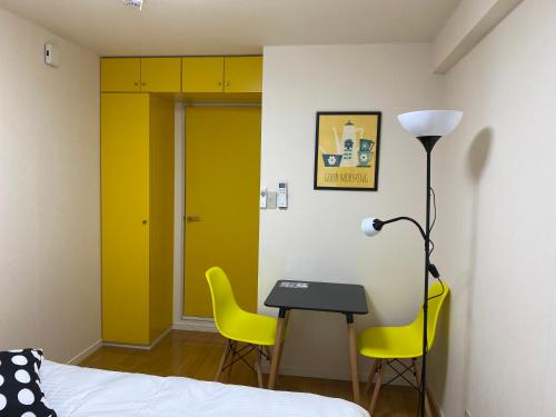 德岛Melody Heim 2C的一间卧室配有书桌和两张黄色椅子