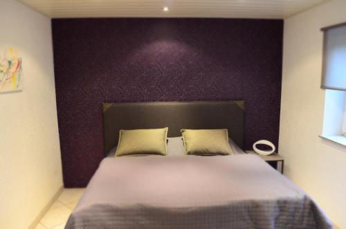 雷德斯塔德Wohnung Ahorn的一间卧室配有一张大床和紫色墙壁