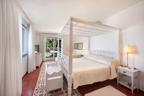 索伦托布里斯托尔酒店的一间卧室设有天蓬床和窗户。