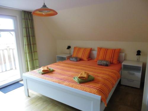 BresewitzEiscafe&Pension Schumann的一间卧室配有一张带橙色枕头的大床