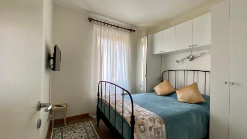 洛韦雷Casa Anna的一间卧室配有一张带蓝色床单的床和一扇窗户。
