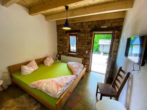 DubovskoHoliday park Hajducka cesma的一间位于客房内的带绿床的卧室