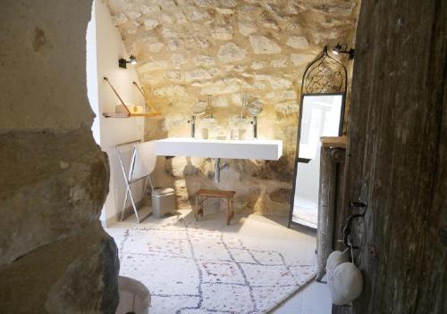 蒙布兰莱班La Maison de Marguerite的一间带水槽和石墙的浴室