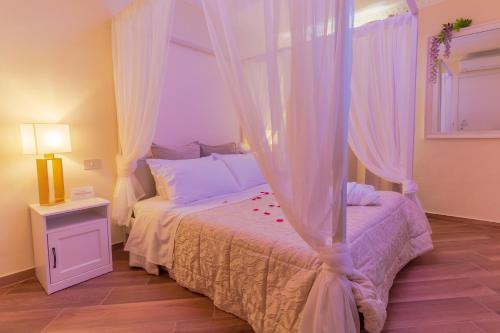 圣玛格丽塔-利古雷Historia Vitiello: The First Experience Suite的一间卧室配有一张带天蓬的床