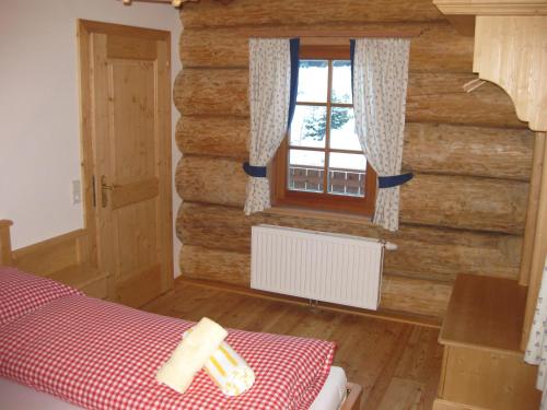 JenigBärenhütte Tröpolach-Nassfeld的一间卧室设有木墙和窗户