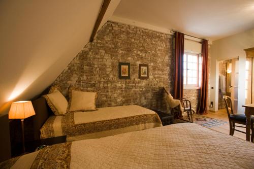 德平特威洛斯洛奇床和早餐的一间卧室设有两张床和砖墙