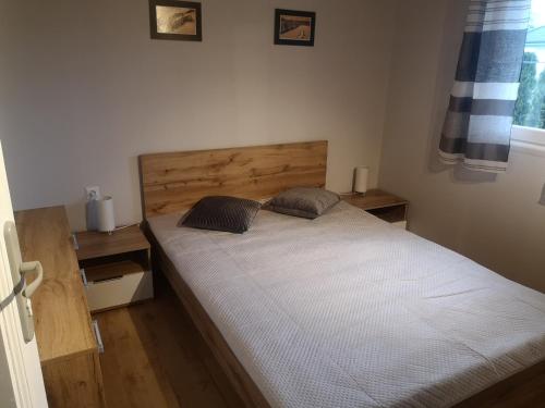 科乌切沃Domek letniskowy的一间卧室配有一张大床和木制床头板