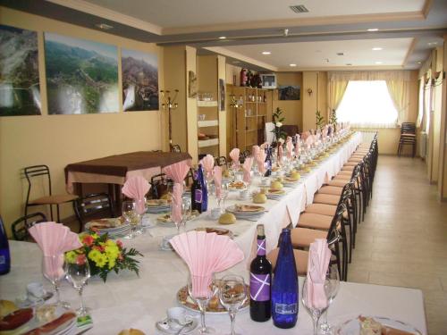 瓜尔多蒙塔尼亚帕伦蒂娜酒店的一张长桌子、椅子和葡萄酒瓶