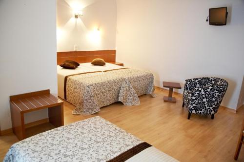 雷根古什-迪蒙萨拉什太阳阿尔克瓦酒店的酒店客房,配有两张床和椅子