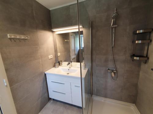Draga BašćanskaRelax House Rosemary的浴室配有盥洗盆和带镜子的淋浴