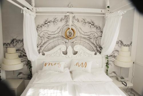 瑟绍胡博图斯酒店的一间卧室配有一张白色床和金色床头板