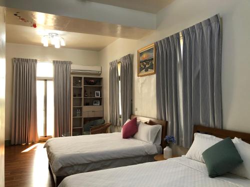 Shui-shang傅院子民宿的一间卧室设有两张床和窗户。