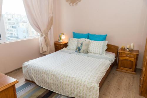 布尔加斯ELEVATING MOMENTS的一间卧室配有一张带蓝色枕头的床和一扇窗户。