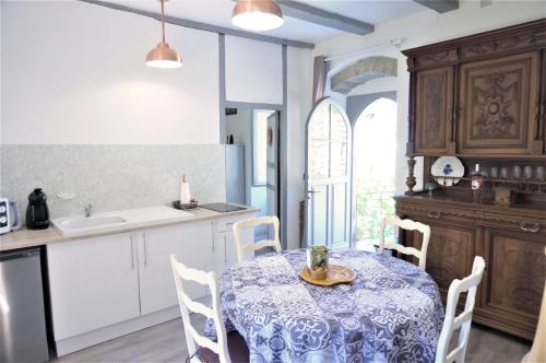 圣锡尔克－拉波皮gite du tourneur的厨房配有桌椅和水槽。