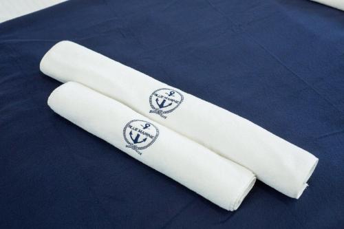 波德贝Apartament 12B Blue Marine Poddąbie的两条白色滚毛巾,坐在床上