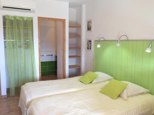 普罗皮亚克马斯德萨格兰蒂尔度假屋的卧室配有白色大床和绿色墙壁