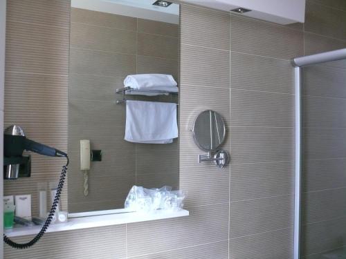 瓜尼佐Hotel Los Angeles的一间带镜子和电话的淋浴的浴室
