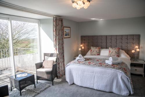 赫尔斯顿Tregaddra Farm B&B的一间卧室设有一张床和一个大窗户