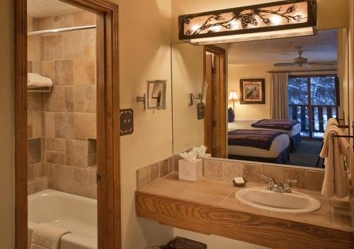 陶斯滑雪谷阿尔卑斯一田一墅套房酒店的带浴缸、水槽和镜子的浴室