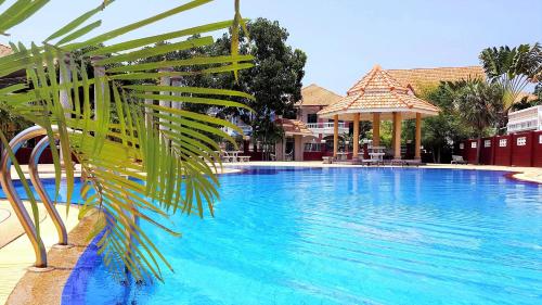 南芭堤雅JOOPLAND Luxury Pool Villa Pattaya Walking Street 6 Bedrooms的前方的蓝色游泳池,棕榈树