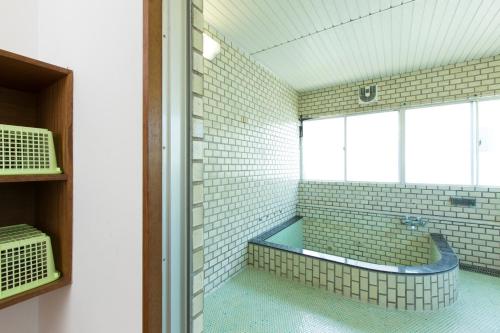 锯南町保田日落微风酒店的一间带浴缸的浴室,位于带窗户的客房内