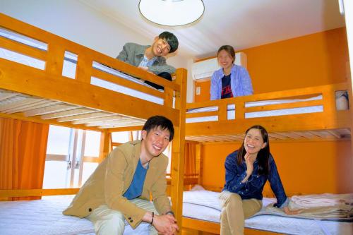 高知ゲストハウス ルルル 最大12名可 合宿 大家族 団体旅行にオススメ的一组坐在双层床上的人