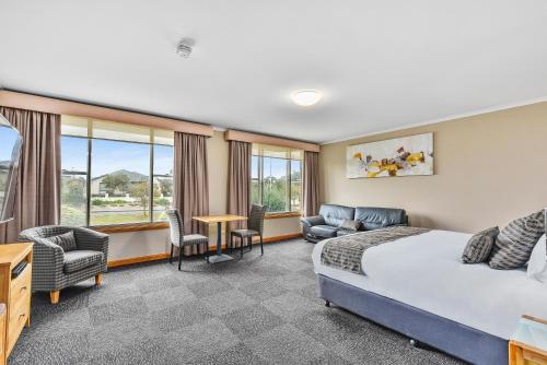 芒特甘比尔Southgate Motel的酒店客房带一张床、一张桌子和椅子