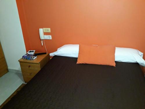 费罗尔Porta Nova Apartamentos的一间卧室配有一张橙色墙壁的床