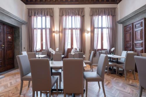 威尼斯Hotel Palazzo Martinelli Dolfin的用餐室设有桌椅和窗户。