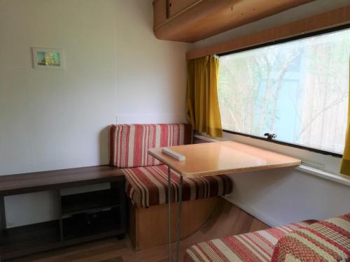 萨姆滕斯Caravan的小房间设有桌子和窗户