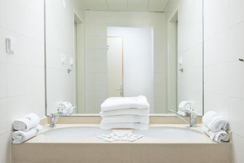 Buqei‘aHI - Pkiin Hostel的浴室配有带镜子的盥洗盆和毛巾