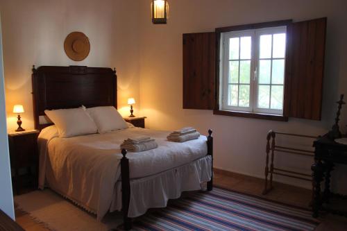 São DomingosMonte do Pinheirinho的一间卧室配有一张带两盏灯的床和一扇窗户。