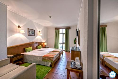 阿尔布费拉科利纳多玛酒店的酒店客房,设有两张床和一张沙发