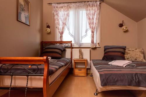 萨希诺Agroturystyka Gawryś pokoje的一间卧室设有两张床和窗户。